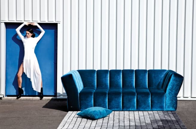 woman posing next to sofa