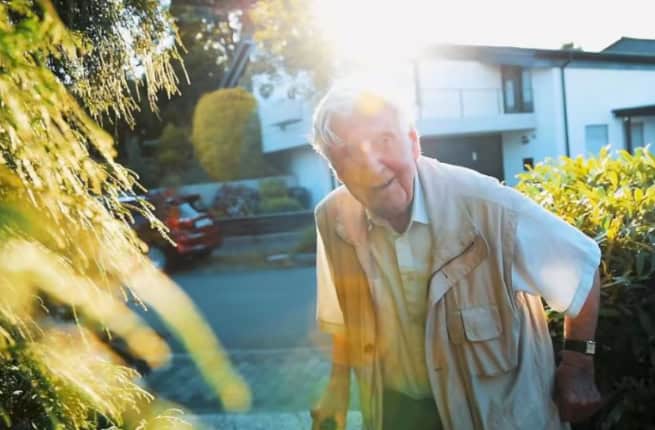 old man in front of house